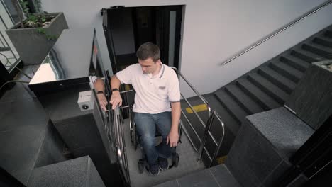 special elevator for the person with a physical disabilities. a man in a wheelchair uses a special elevator