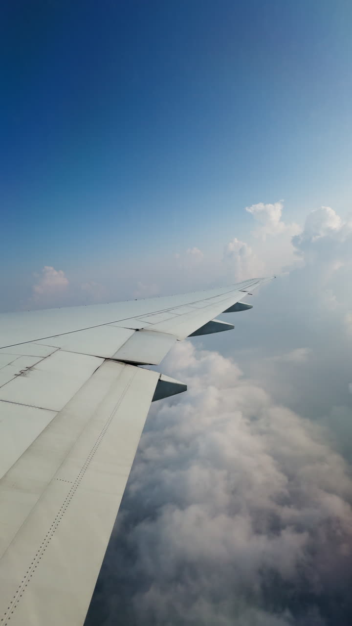 Udsigt fra et flyvindue af himlen med vingen, optaget vertikalt