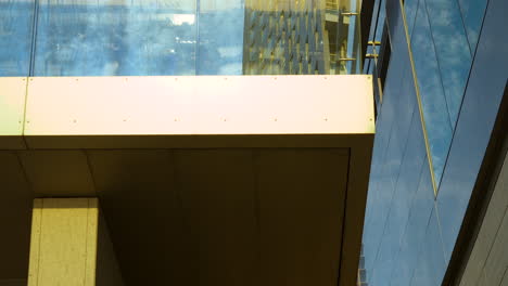 detalle de edificio moderno con fachada de vidrio azul y accesorios metálicos visibles