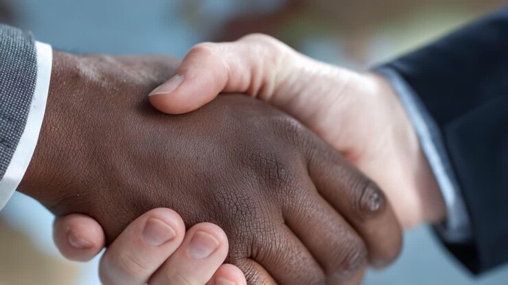 Un potente gesto di unità: due mani che si stringono saldamente, a simboleggiare fiducia e collaborazione tra background diversi