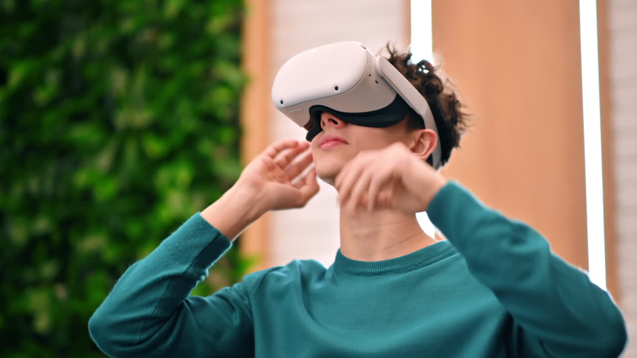 A young excited caucasian man exploring virtual reality using VR glasses in an office