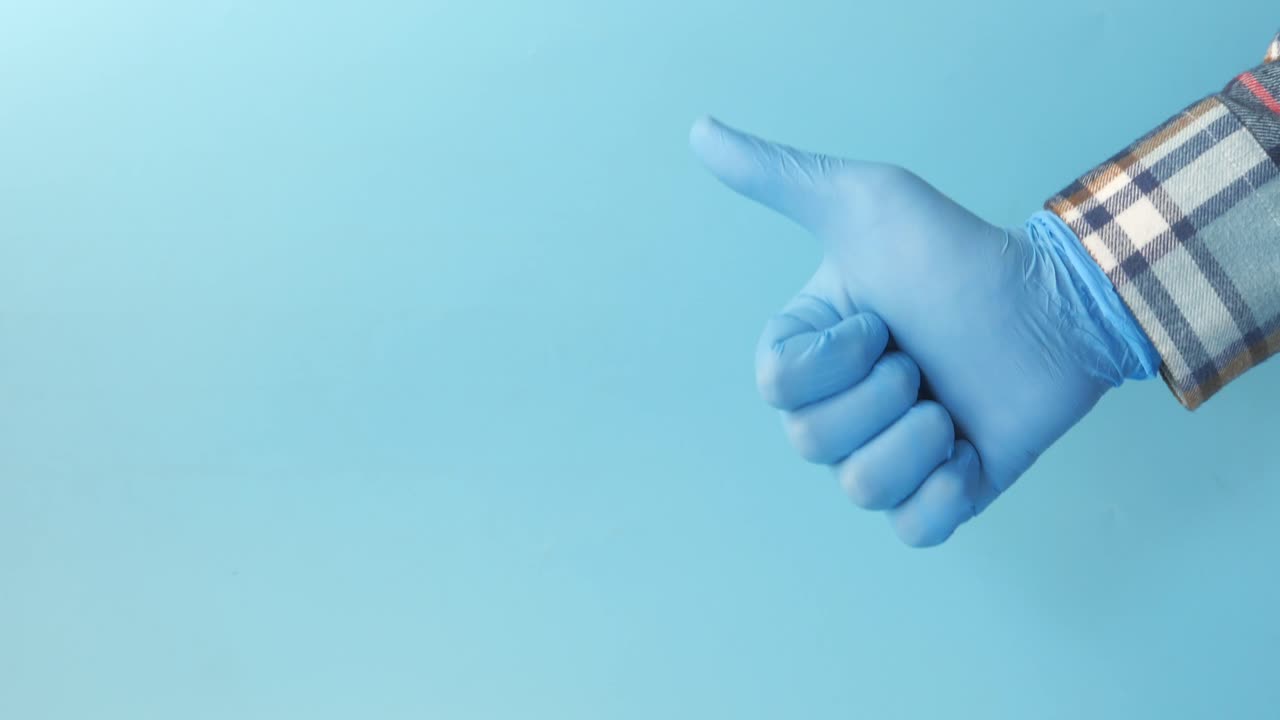 파란 장갑을 입은 손으로 엄지손가락을 올리고