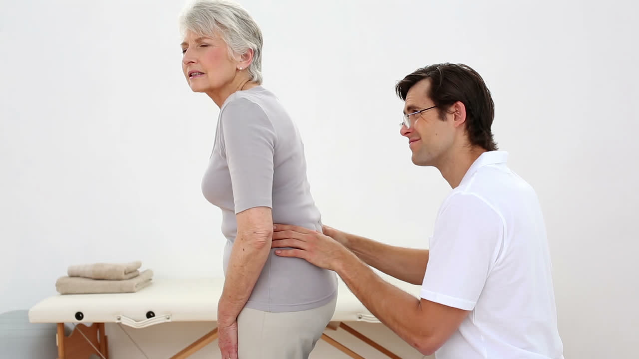 fisioterapeuta revisando a los pacientes mayores de vuelta