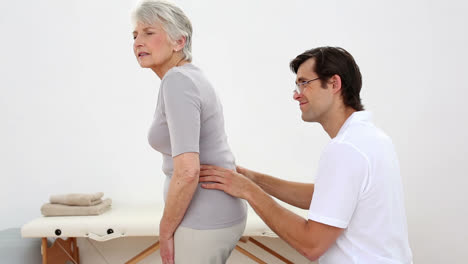 Physiotherapist-checking-senior-patients-back