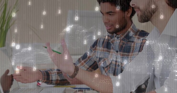 Designer con camicia a quadri che ruota una ruota dei colori dopo che un collega ha indicato lo schermo, affinando la palette di design.