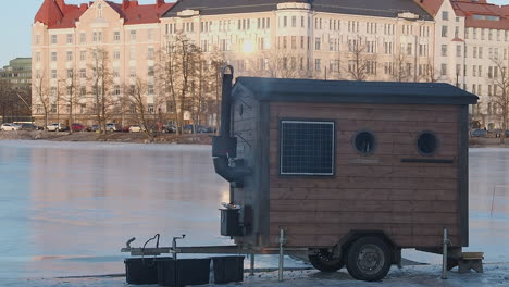 Charmante-Kleine-Mobile-Holzfeuersauna-Auf-Einer-Eislaufbahn-Im-Freien