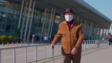 senior pensioner tourist grandfather wearing protective face mask, avoid coronavirus near airport