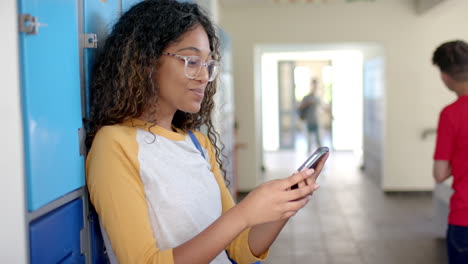 teenage biracial girl checks her phone at high school, with copy space