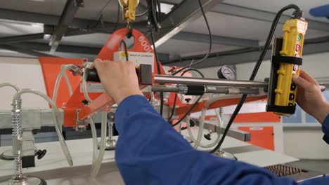 worker uses suction cups for transporting large sheets of metal