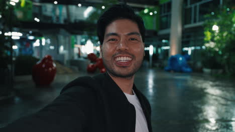 happy man taking a selfie at a night mall