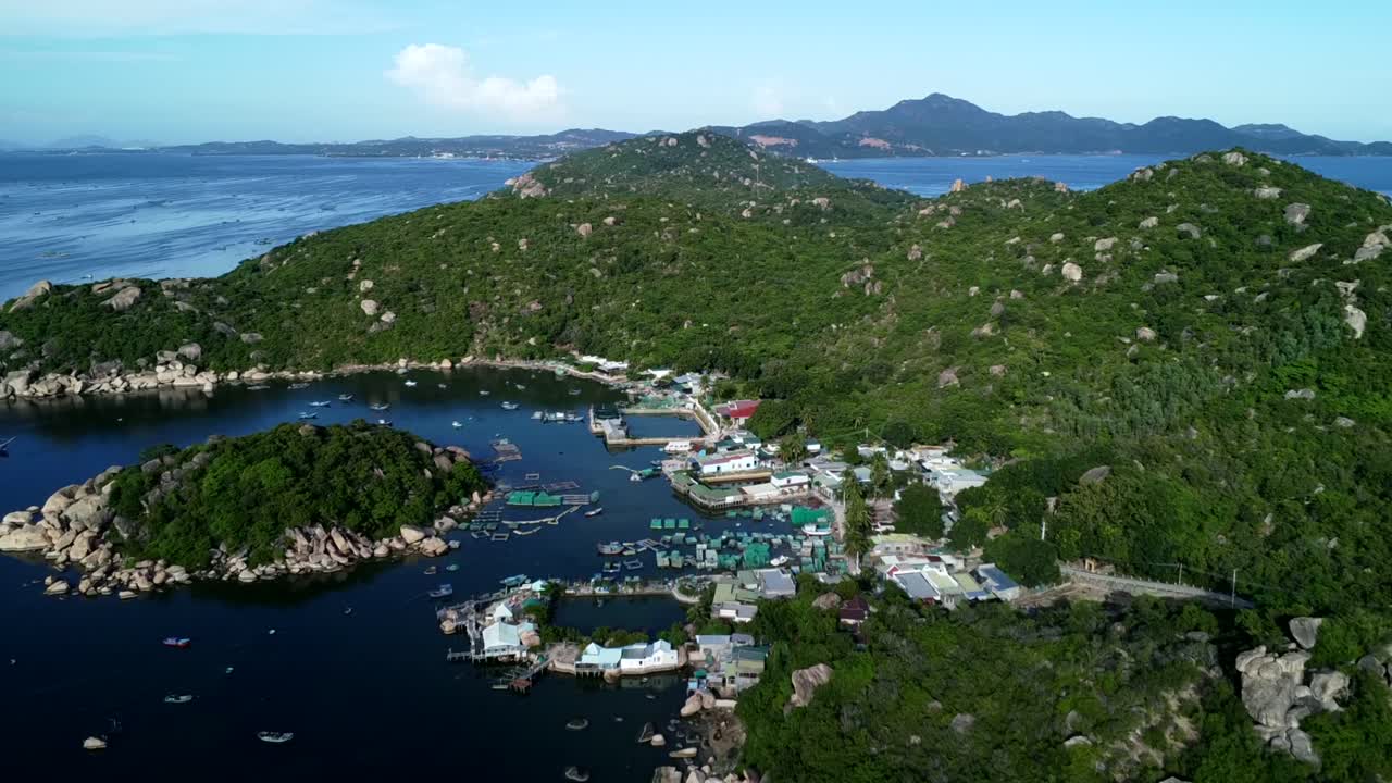 Cảnh quay từ drone trên không của làng chài nổi Cái Bèo với các trại nuôi cá, thuyền bè và nhà cửa dọc theo vịnh yên bình được bao quanh bởi những ngọn đồi xanh ở Vịnh Lan Hạ gần Đảo Cát Bà, Việt Nam.