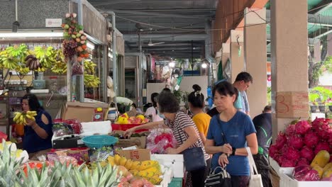 customers picking and selecting fresh fruits in whampoa wet market, singapore.