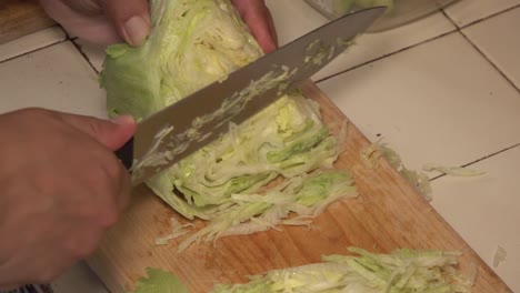 Lechuga-Cortada-En-Trozos-Pequeños-En-Una-Tabla-Para-Cortar