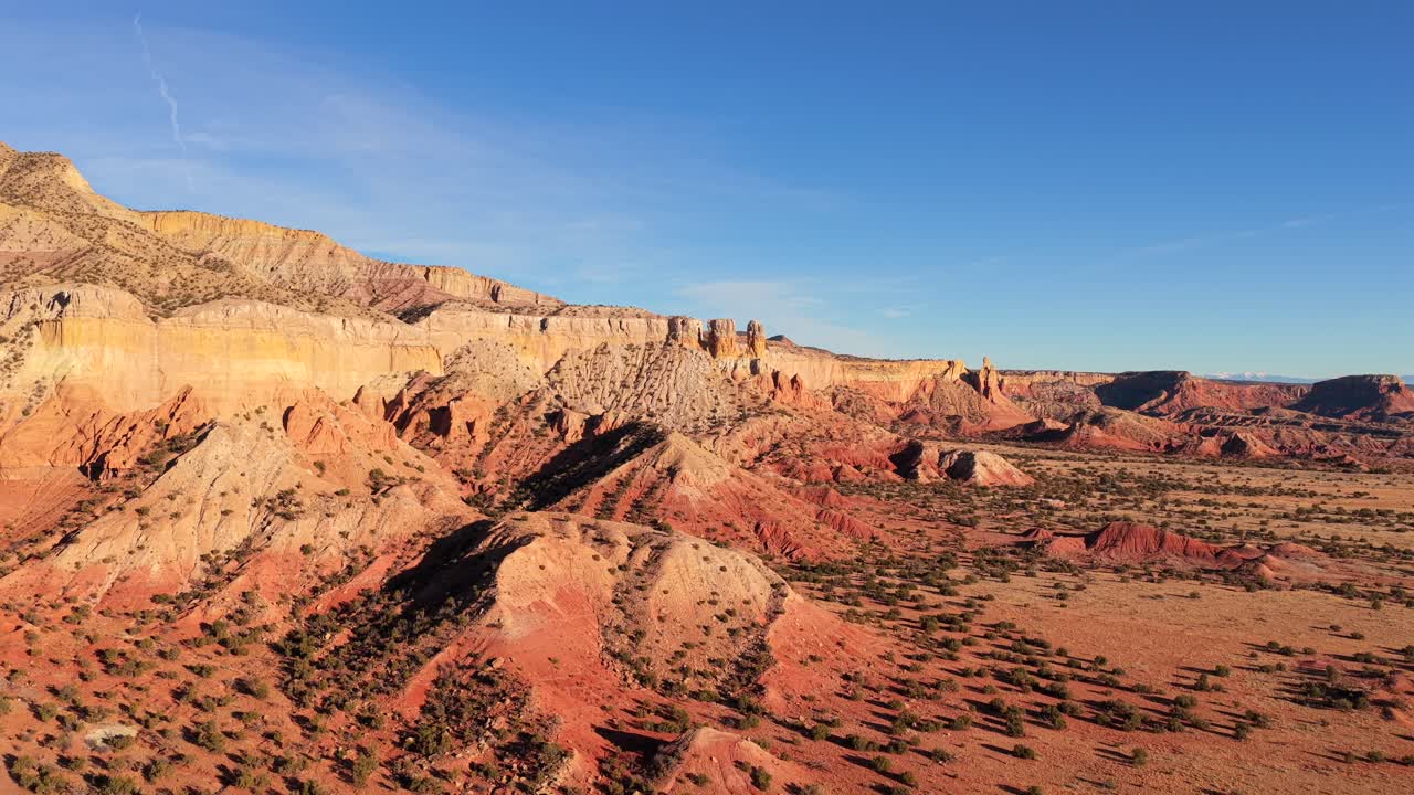 Filmati professionali realizzati con drone mostrano l'imponente scogliera di arenaria multicolore e la vasta distesa desertica di Abiquiu, nel New Mexico settentrionale. Perfetti per il cinema a tema western e per i media di viaggi.