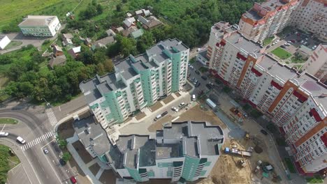flying over the modern residential buildings and green trees in the town. new houses with residential apartments. aerial view