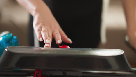 lady commences treadmill by activating start button closeup. woman sets speed of gym apparatus for indoor fitness sessions. technology in sports equipment