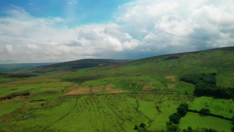 Aerial-landscape-showing-lush-green-countryside-under-a-bright-blue-sky,-in-the-English-Lake-District