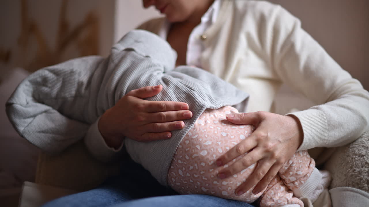 Mamma sorridente che tiene delicatamente in braccio un bambino all'interno di un bar