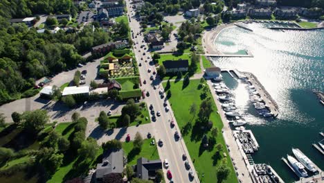 Panning-drone-shot-of-traffic-through-sister-bay,-wisconsin-on-a-busy-day