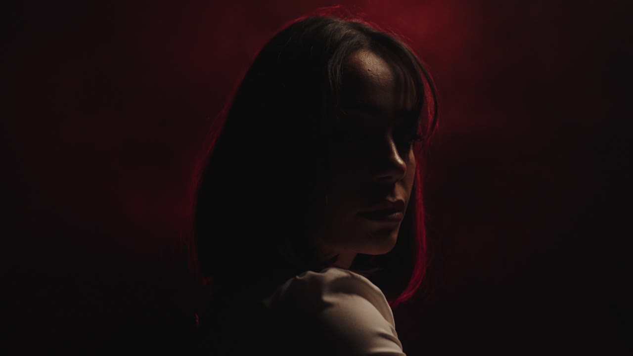 Mysterious woman in the dark with fog. side view close up and red light