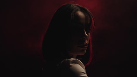 mysterious woman in the dark with fog. side view close up and red light