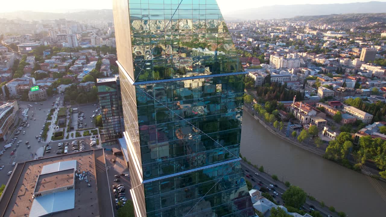 유리 마천루 위의 해가 지는 도시 반사