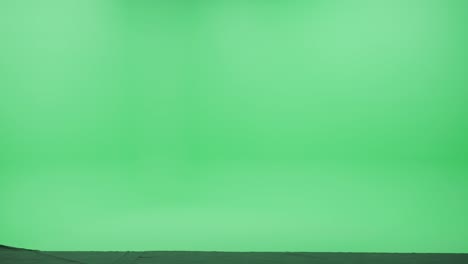 pantalla verde chroma clave estudio: fuerte hombre guapo con ropa casual camina a través de la habitación de izquierda a derecha. vista lateral disparo de la cámara