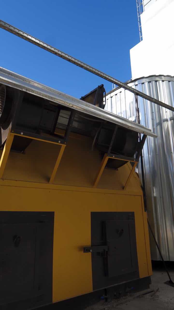 Industrial equipment on agricultural plant. Exterior of modern factory for grain processing. New equipment for agribusiness. Grain elevator. Vertical video