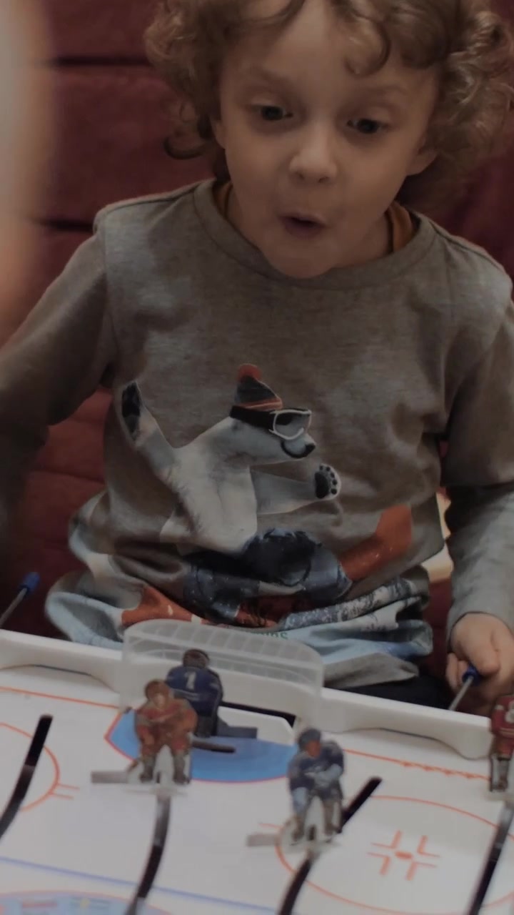 Ragazzo che gioca a hockey da tavolo con il nonno