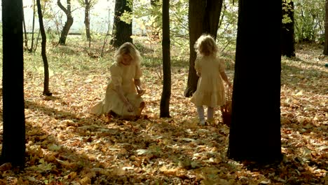 happy mother with yellow maple leaflets hugs her daughter in autumn forest