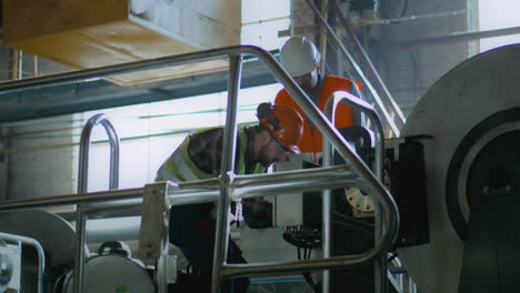 factory workers inspecting industrial machinery