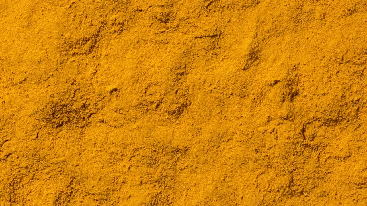 polvo de especias de cúrcuma y cúrcuma en marco completo con costuras en bucle