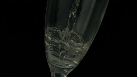 Champagne-pouring-into-flute-on-black-background