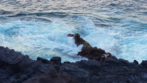 rocks being swallowed by waves of water from the sea in canary island, tenerife, static slow motion