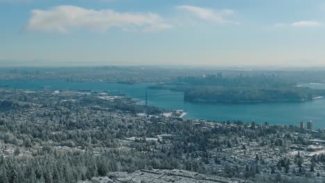 amplia vista aérea de drones de vancover cubierta de nieve con el puente de la puerta de los leones en la distancia