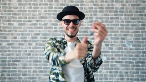 happy stylish man posing in front of brick wall