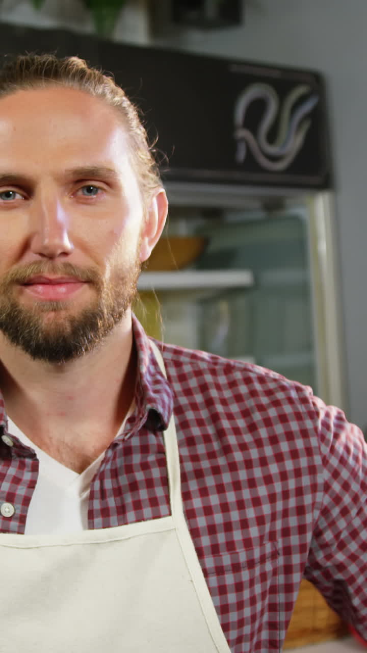 personal masculino sonriente de pie con los brazos cruzados en la sección de panadería