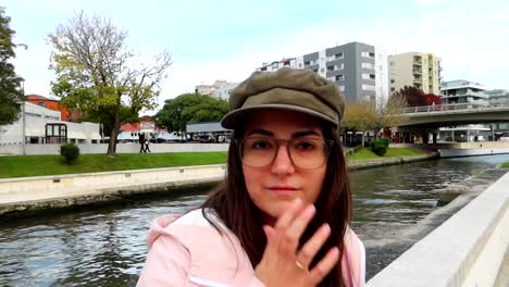 Woman-with-green-bonnet-touches-its-glasses-and-smiles-while-looks-at-the-camera