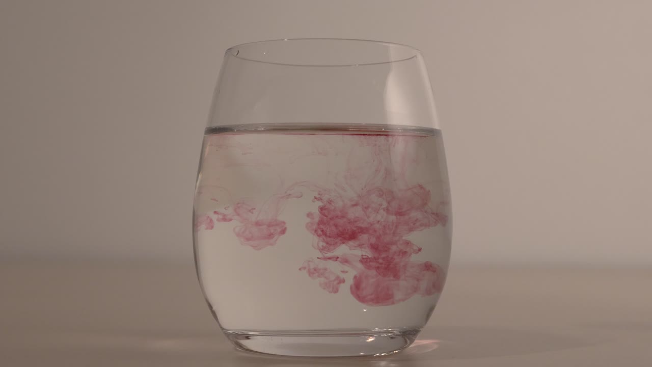 물 한 잔 속에서 춤추는 붉은 방울