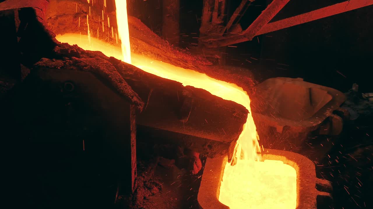 금속공학 개념: 금속공장에서 녹은 금속은 공장 장비를 통해 흐르고 있습니다.