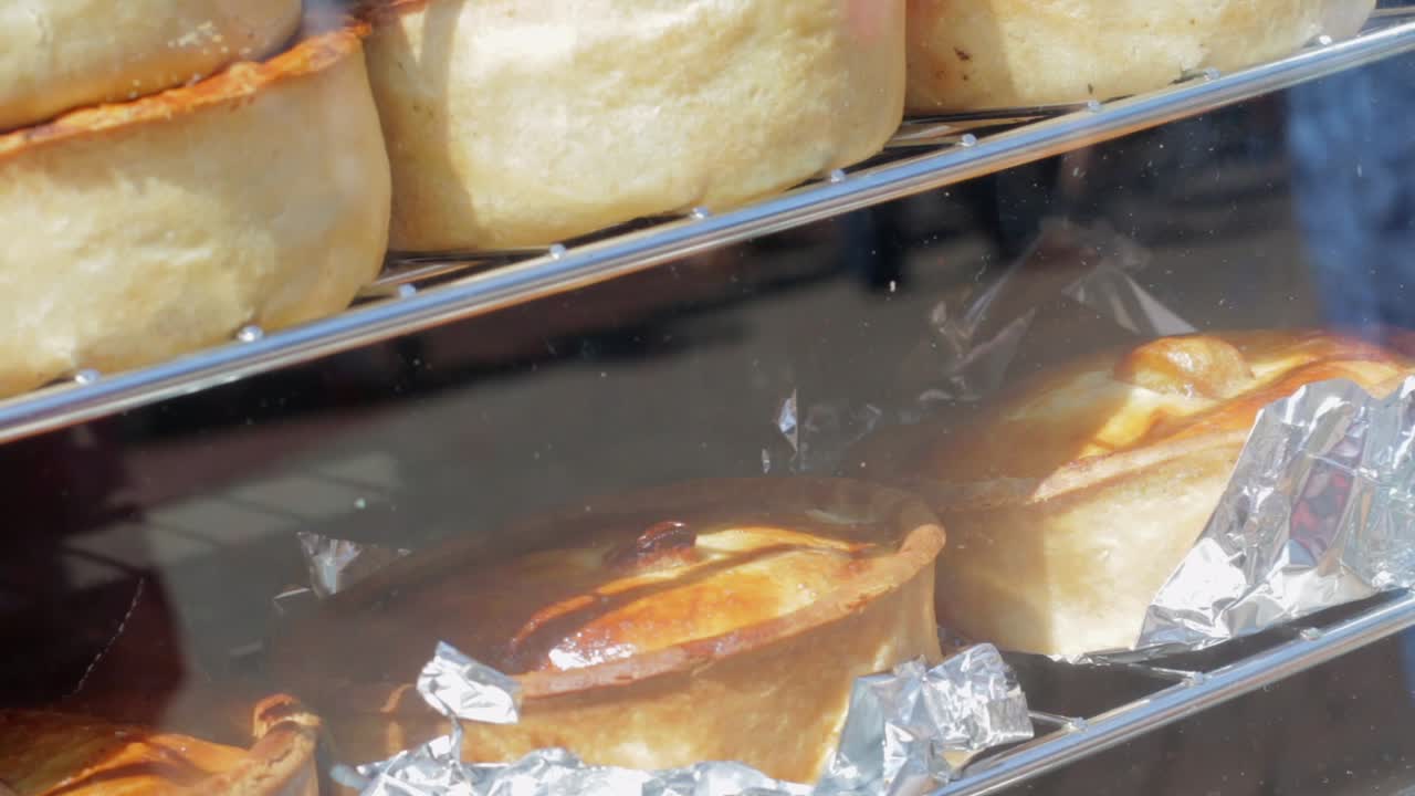 Pies in a display case at at a street food market.