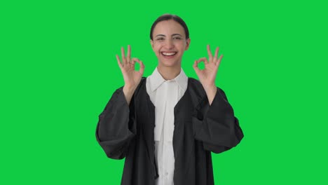 una feliz abogada india mostrando una pantalla verde con un letrero de acuerdo