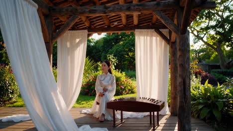 a woman playing a traditional chinese instrument in a serene outdoor gazebo