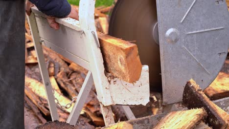 Sah,-Wie-Man-Kiefernholz-Schneidet,-Um-Sich-Auf-Den-Winter-Vorzubereiten---Nahaufnahme-Von-Säge-Und-Brennholz,-Die-In-Eine-Volle-Schubkarre-Fallen