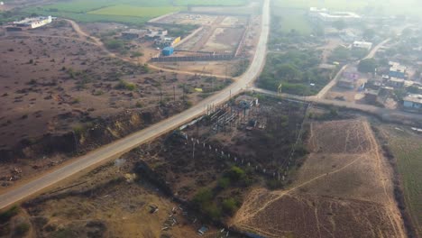 tomada aérea de un avión no tripulado de una planta de electricidad de pequeña capacidad a lo largo de una carretera de un pueblo en madhya pradesh, india