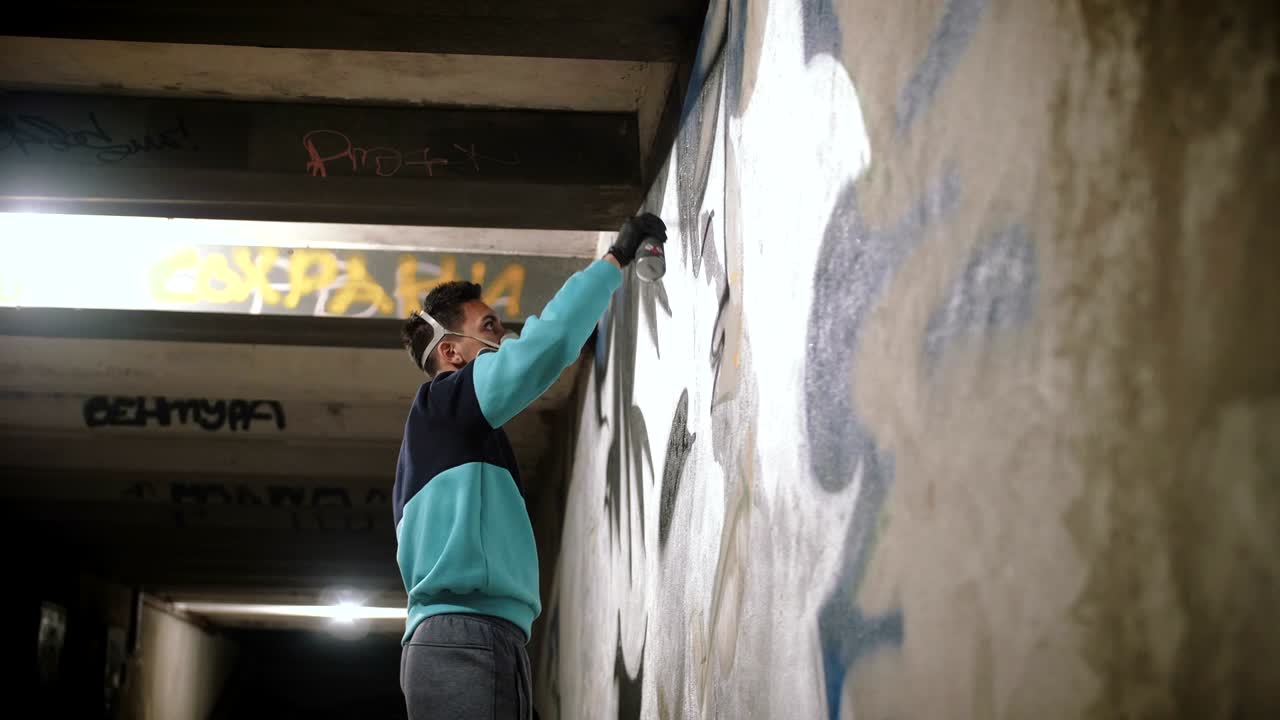 artista de graffiti pintando en la pared en el metro