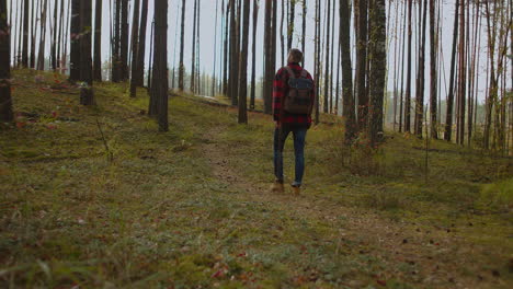 Outdoor-Activities-Travel-Concept-Man-in-Nature.-Back-View-of-Walking-Person-on-Field-Road-in-National-Park.-One-30s-Tourist-Walks-on-an-Adventure-Trip-in-Natural-Landscape-in-Hike-on-a-Environment.-High-quality-4k-footage