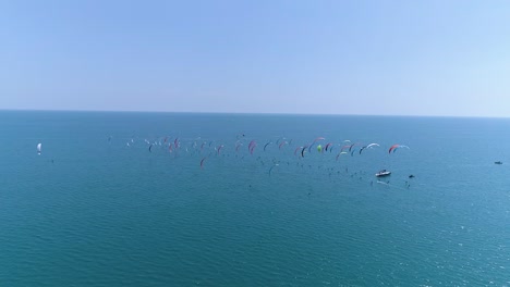 group of kitesurfers racing, view from behind by drone.