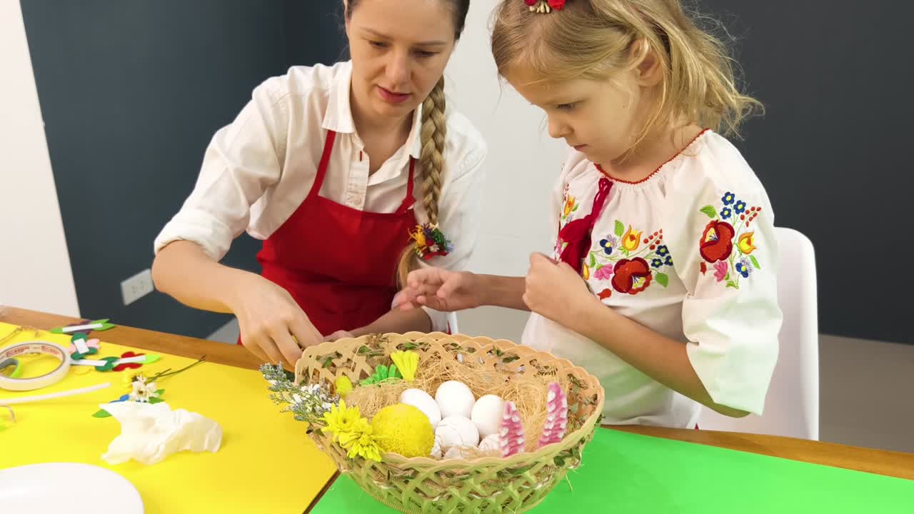 Mother and daughter decorating Easter eggs in a basket