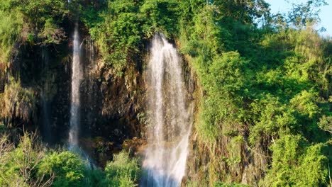 The-natural-waterfall-that-flows-down-the-mountain-is-lit-by-the-evening-sun